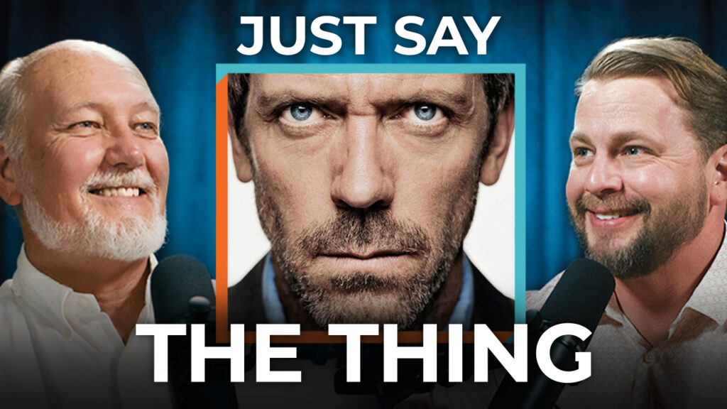 Two men speak into microphones on either side of an intense face. Bold text reads: "Just Say The Thing." Value clarity every time.