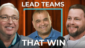 Three men smile and hold microphones in front of orange text: "Lead High-Performance Teams That Win" on an orange background.