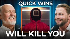 Two men speak into microphones with a Squid Game masked figure between them. Text: "Quick Wins Will Kill You." Stresses strategy over tactics.