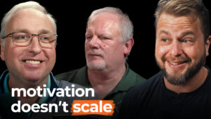 Three smiling men appear under the phrase "motivation doesn't scale" on a black background, emphasizing discipline drives business success.