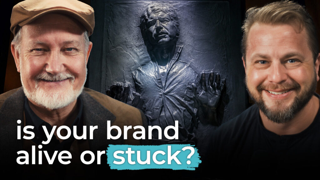 Two men smile with a frozen figure behind them. Text in front reads "is your brand alive or stuck?" highlighting brand consistency.